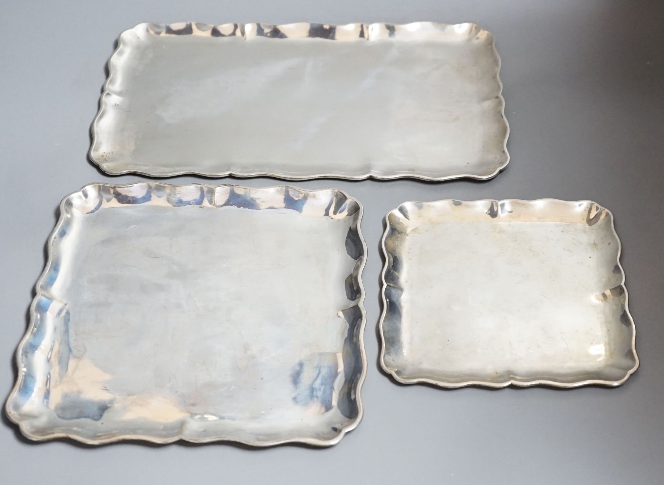 A graduated suite of three Austro-Hungarian white metal trays with wavy borders, largest 34.5cm, 36oz.